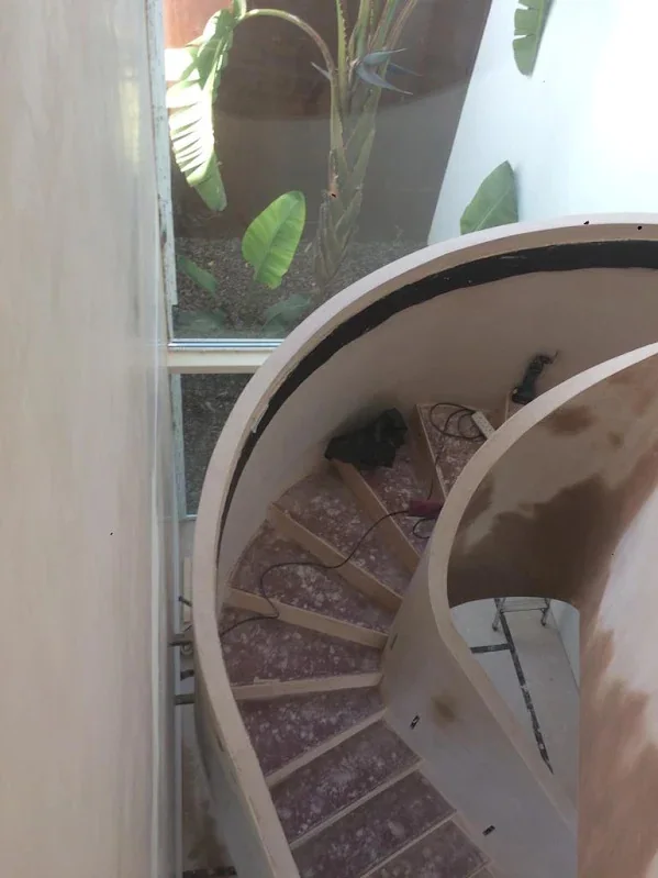 Curved wall wrapping the top of a spiral staircase, floated and skimmed to the curve