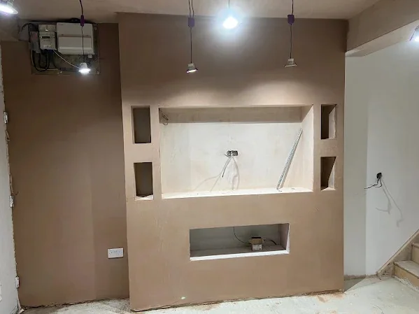 Media wall skimmed with alcoves either side and the downlights already in