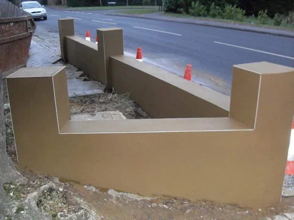 Roadside boundary wall rendered over its full length, every pier squared up
